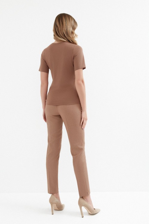 Na modelce top z krótkim rękawem, w kolorze jasnego brązu.