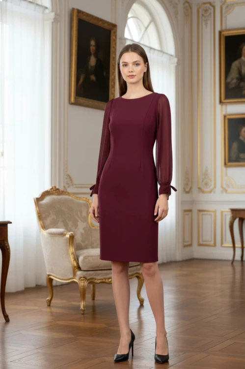 Na modelce stojącej przodem, bordowa, dopasowana sukienka o długości do kolan, z długim, szyfonowym rękawem oraz okrągłym dekoltem