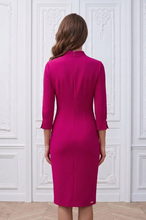 Na modelce stojącej tyłem, lekko dopasowana sukienka w kolorze amarantowym,  zapinana na długi kryty suwak