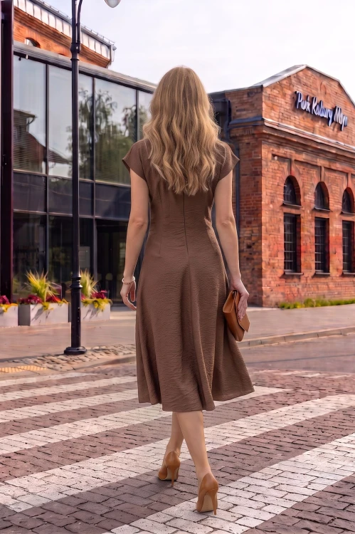 Na modelce stojącej tyłem sukienka midi w kolorze mlecznej czekolady, delikatnie rozkloszowana,rękaw krótki reglanowy, zapinana na długi kryty suwak