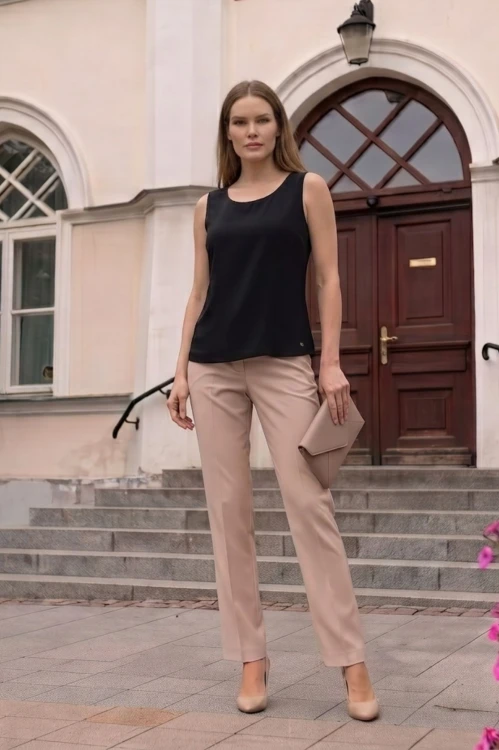 Na modelce stojącej przodem klasyczny top bez rękawów w kolorze czarnym, dekolt okrągły