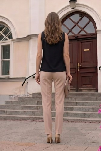 Na modelce stojącej tyłem klasyczny top bez rękawów w kolorze czarnym