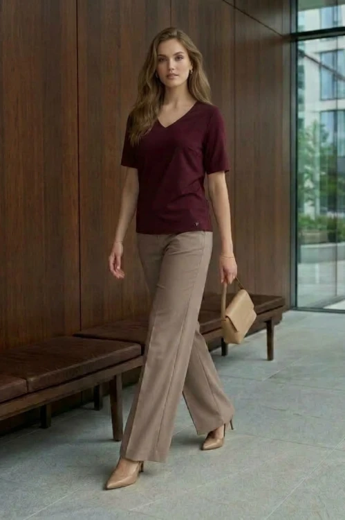Na modelce top z krótkim rękawem, w kolorze bordowym z dekoltem w serek.